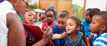 Teacher reading a book with a class of preschool children